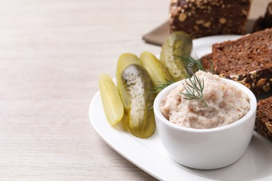 Photo of Delicious lard spread, bread and pickles on wooden table. Space for text
