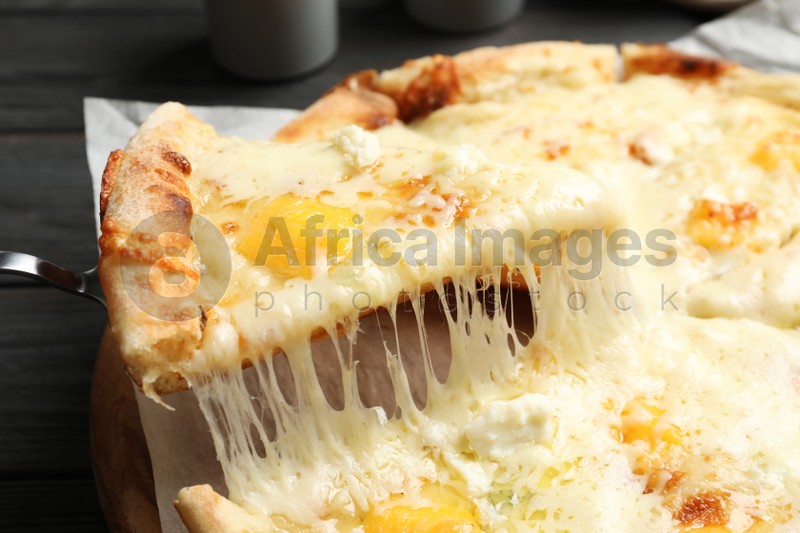 Photo of Taking slice of hot cheese pizza Margherita on table, closeup