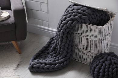 Storage basket with soft chunky knit blanket in room
