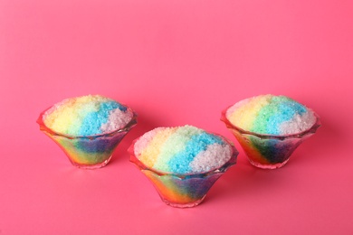 Rainbow shaving ice in glass dessert bowls on pink background