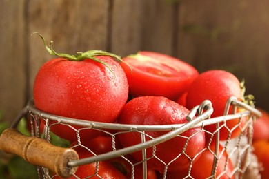 Fresh ripe tomatoes in metal basket, closeup