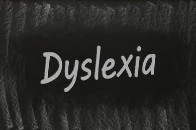 Illustration of Word Dyslexia written on dirty black chalkboard