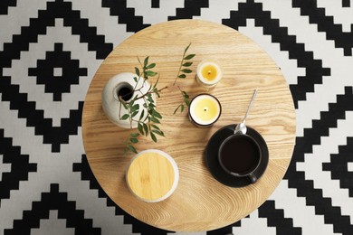 Freshly brewed coffee and decorative elements on wooden table, top view