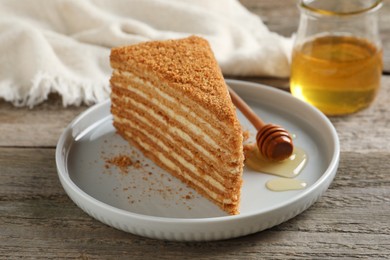 Photo of Slice of delicious layered honey cake served on wooden table
