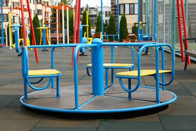 Empty outdoor children's playground with merry-go-round in residential area