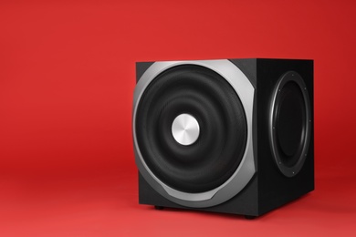 Modern subwoofer on red background. Powerful audio speaker
