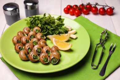Delicious cooked snails served on white table