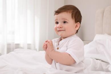 Cute baby boy on bed at home