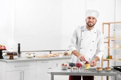 Photo of Male pastry chef preparing dessert at table in kitchen