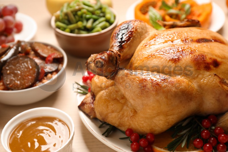 Traditional Thanksgiving day feast with delicious cooked turkey and other seasonal dishes served on wooden table, closeup