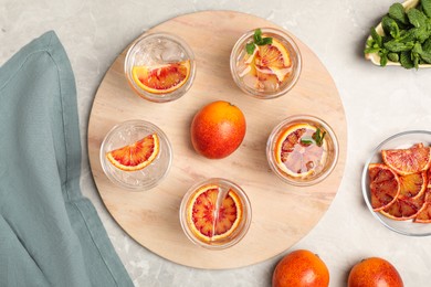 Delicious refreshing drink with sicilian orange on light grey marble table, flat lay