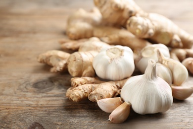 Ginger and fresh garlic on wooden table, closeup. Natural cold remedies