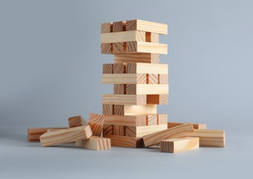 Jenga tower made of wooden blocks on grey background