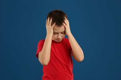 Portrait of emotional preteen boy on blue background