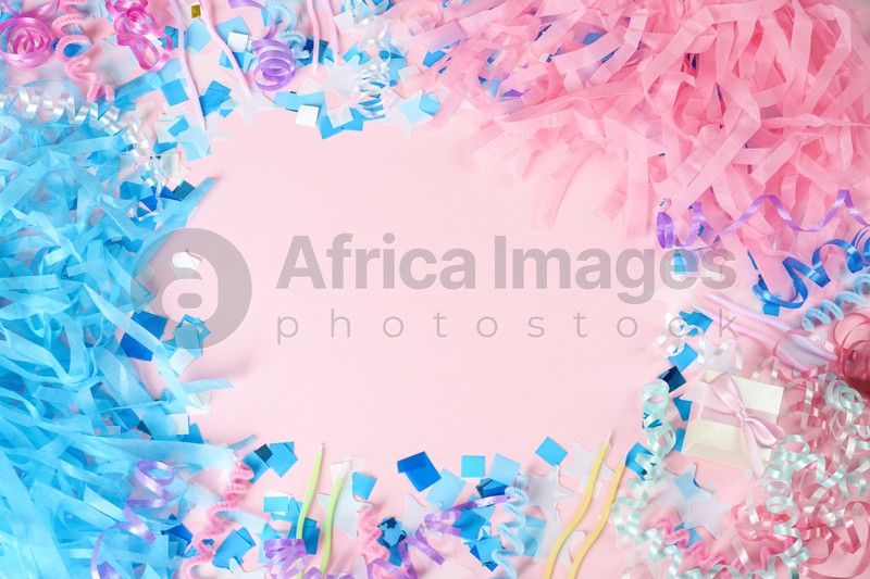 Frame of colorful serpentine streamers and other party accessories on pink background, flat lay. Space for text