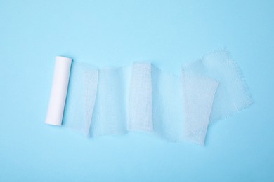 Photo of White medical bandage on light blue background, top view
