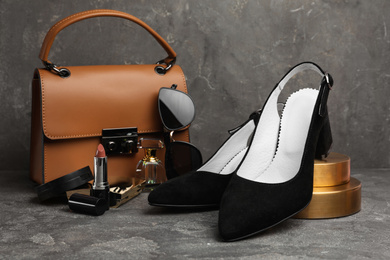 Composition with stylish black female shoes on grey stone table