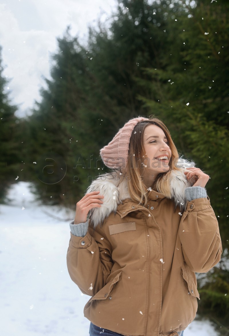 Young woman in snowy conifer forest. Winter vacation