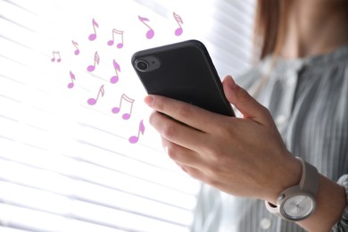 Image of Woman listening to music on mobile phone indoors, closeup. Music notes illustrations near gadget