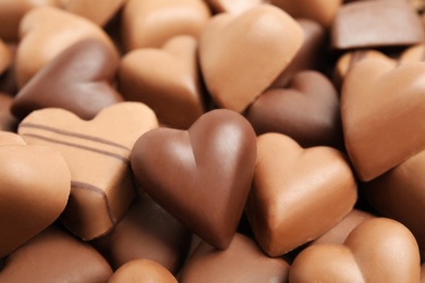 Tasty heart shaped chocolate candies as background, closeup. Valentine's day celebration