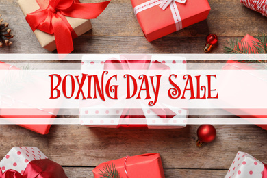 Text Boxing Day Sale and gifts on wooden background, top view