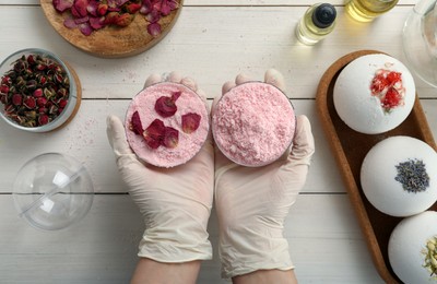 Woman in gloves making bath bomb at white table , top view