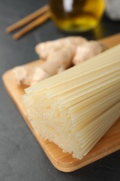 Photo of Dried rice noodles with ginger on black table, closeup