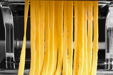 Pasta maker machine with raw dough , closeup