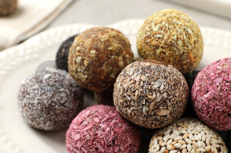 Different delicious vegan candy balls on plate, closeup