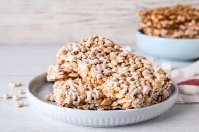 Delicious rice crispy treats on white wooden table, closeup