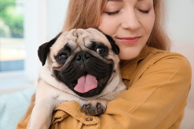 Woman with cute pug dog at home, closeup. Animal adoption