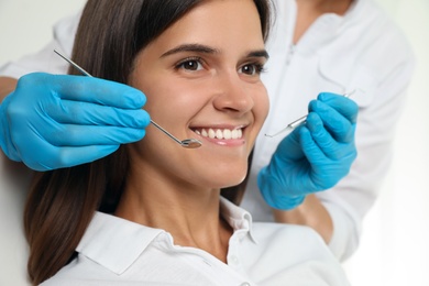 Dentist examining patient's teeth in modern clinic, closeup. Cosmetic dentistry