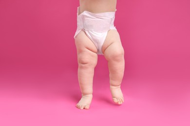 Little baby in diaper on pink background, closeup
