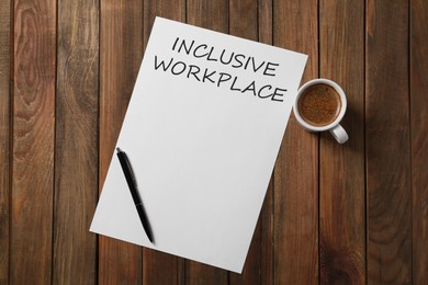Inclusive workplace. Paper, pen and cup of coffee on wooden table, flat lay
