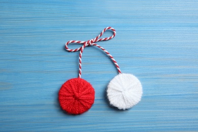 Photo of Traditional martisor on blue wooden background, top view. Beginning of spring celebration
