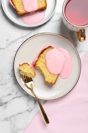 Delicious cake with pink glaze served on white marble table, flat lay