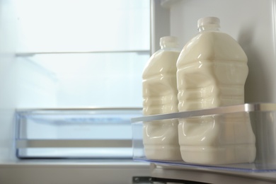 Gallons of milk in refrigerator, closeup. Space for text
