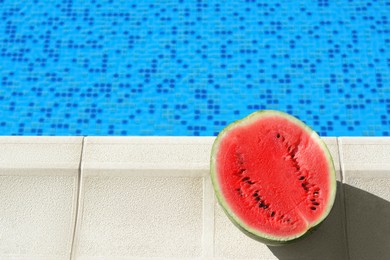 Photo of Half of fresh juicy watermelon near swimming pool outdoors. Space for text