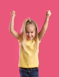 Portrait of excited little girl on pink background