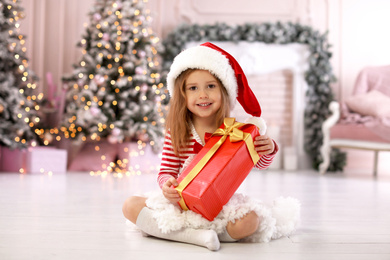Cute little child with Christmas gift at home