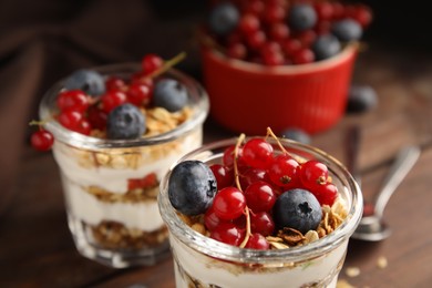Delicious yogurt parfait with fresh berries on table, closeup