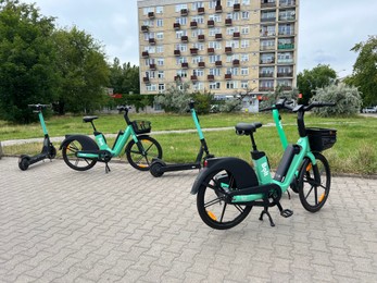 Photo of Electronic scooters and bicycles parked on city street