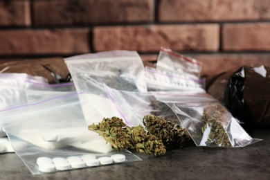 Hemp and other drugs in packages on grey  table