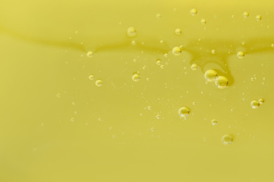 Pure transparent cosmetic gel on yellow background, closeup