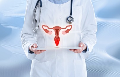 Doctor demonstrating virtual image of infected female reproductive system on light background, closeup. Vaginal candidiasis