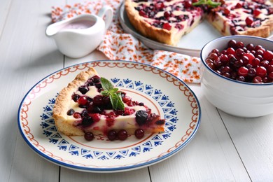 Piece of delicious currant pie served on white wooden table