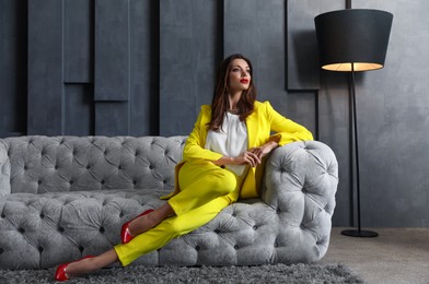 Beautiful businesswoman on sofa indoors. Luxury lifestyle