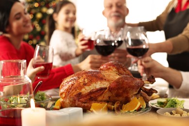 Family enjoying festive dinner at home, focus on delicious baked turkey. Christmas celebration