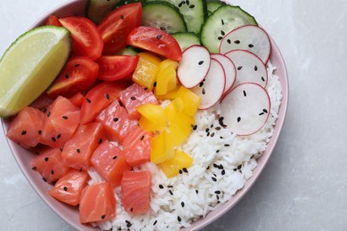 Delicious poke bowl with salmon, rice and vegetables on light grey table, top view