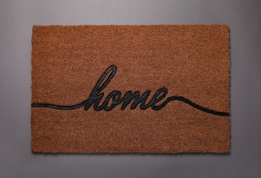 Photo of Doormat with word Home on grey background, top view